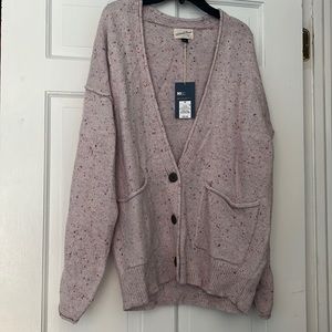 Pink cardigan with scattered rainbow spots